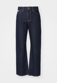 Mörkblå denimjeans med vid bendesign, med en klassisk femficksstil och kontrasterande sömnadsdetaljer.