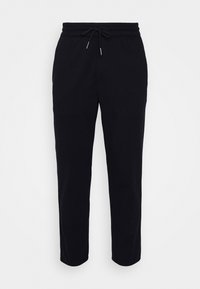 Zwarte joggingsbroeken van zachte stof, met een elastische tailleband met een trekkoord en taps toelopende pijpen met cuff-ankels.