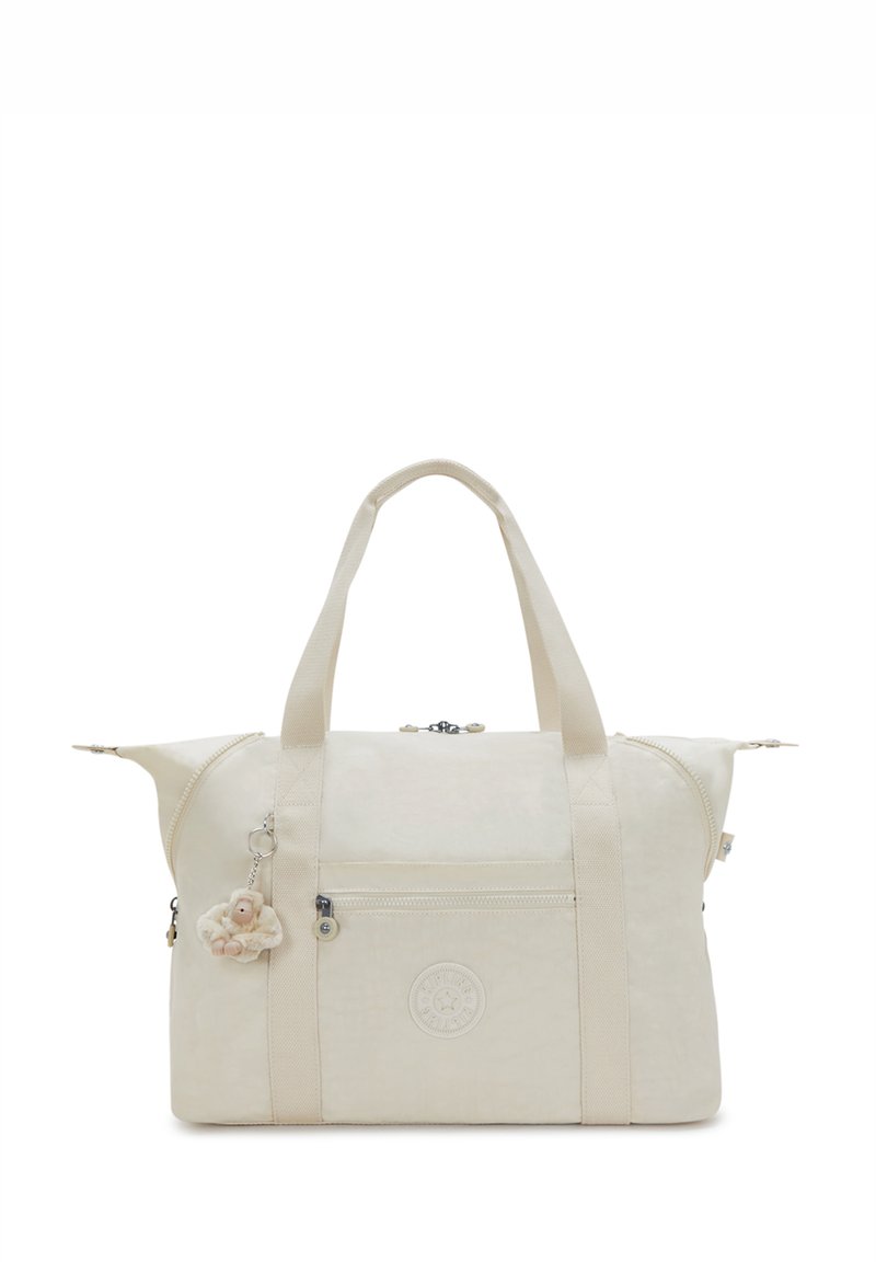 Beige stoffen sporttas met twee bovenhandvatten, ritssluiting, voorvak en decoratieve charme. Heeft een logo dat op de voorkant is gedrukt.