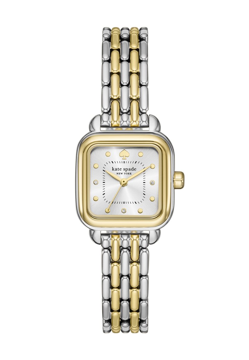 Fyrkantig klocka med ett band av silver och guld. Har en vit urtavla, guldaccenter och juvelprickar som timmarkörer. Anmärkningsvärd spade-logotypdesign.