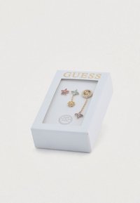 Σετ από πέντε σκουλαρίκια σε λευκό κουτί. Περιλαμβάνει πολύχρωμα σχέδια λουλουδιών και πλακιδίων, χρυσές λεπτομέρειες και λογότυπο. Υλικό από ανοξείδωτο ατσάλι.