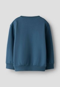 Paprasta mėlyna džemperio suapvalinta apykaklė su ilgomis rankovėmis ir gofruotais rankogaliais bei apačia, rodoma iš nugaros ant šviesiai pilkos spalvos fono.