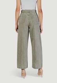 Jeans de pierna ancha color gris claro con cintura alta, con dos bolsillos traseros y dobladillo acampanado, fabricados en denim con una textura sutil.