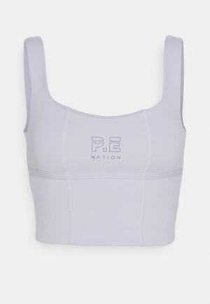 Laventelinvärinen lyhyt urheilutoppi, jossa leveät olkaimet ja "P.E Nation" -logo rinnan keskellä.