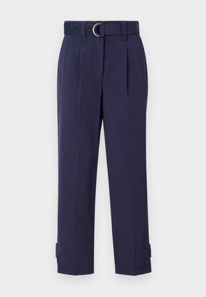 Marineblaue Hosen mit einem Gürtel mit einem silbernen Metallring, ausgestelltem Vorderteil und schmal zulaufenden Beinabschlüssen mit verstellbaren Verschlüssen am Saum.