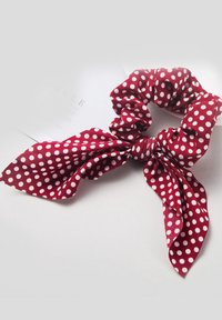 Sarkans ar riņķiem rotāts scrunchie ar piesietu lentu. Izgatavots no mīkstas auduma, ar baltām aplīšu rakstu un teksturētu apdari.