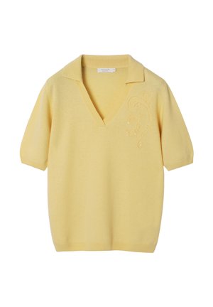 Gul strikket polo med korte ærmer, v-udskæring og dekorativ broderi på venstre side. Blød tekstur, afslappet pasform.