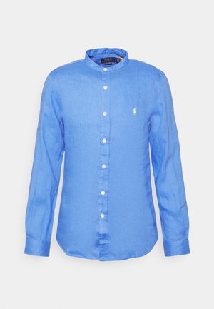 Chemise bleue à manches longues boutonnée avec col mandarin et petit logo jaune Polo Ralph Lauren sur la poitrine.