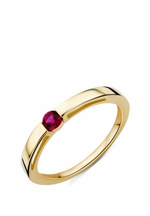Anillo de oro con una única piedra preciosa roja redonda engastada en una banda moderna y minimalista sobre un fondo blanco.