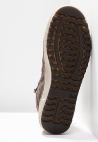 Sole of brown suede boot with deep tread pattern, light beige midsole, zipper on side, and "Gabor" brand on sole.