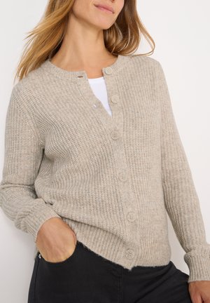 Gilet beige tricoté avec un motif texturé, dotée d'un col en V, de six boutons sur le devant et de poignets côtelés.