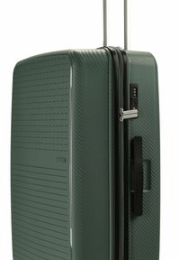 Grüner Hartschalenkoffer mit strukturierten Oberflächen, ausgestattet mit einem schwarzen Reißverschluss, Zahlenkombinationsschloss und ausziehbarem Trolleygriff.