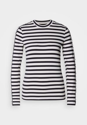Camicia a maniche lunghe con strisce orizzontali bianche e nere a contrasto, scollo tondo e dettagli testurizzati lungo le maniche.