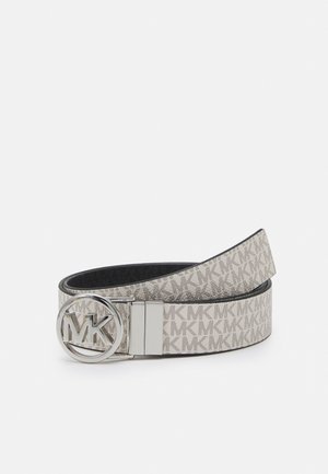 Ceinture beige et grise de créateur avec motif répété "MK" et boucle ronde en argent portant le logo "MK", roulée sur un fond blanc.