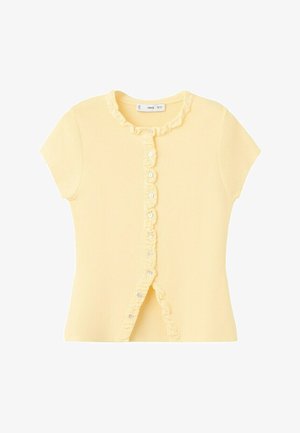 Krátky rukáv bledozltý pletený top s volánikovým lemom pozdĺž zapínania na gombíky a výstrihu, s malými bielymi gombíkmi vpredu.