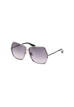 Occhiali da sole esagonali con una leggera montatura in argento, lenti grigie sfumate e accenti in acetato nero sulle tempie. Dettagli trasparenti lungo il davanti.