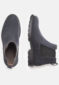 Bottines en suède bleu marine avec panneaux latéraux élastiques, bout rond et semelle en caoutchouc texturée. Dispose d'une languette pour un enfilage facile.
