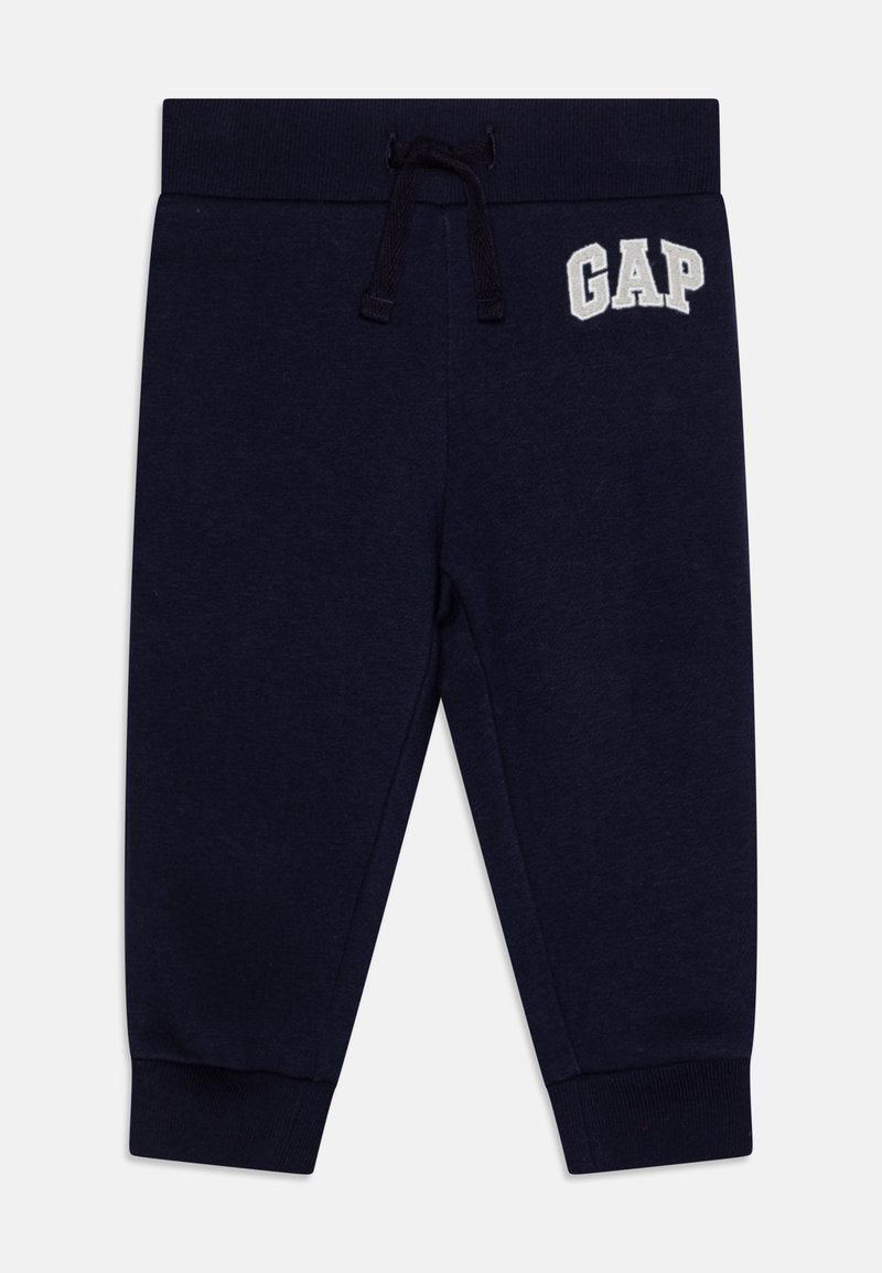 Pantalons de sport bleu marine avec chevilles resserrées, taille à cordon de serrage, et logo "GAP" brodé à l'avant en blanc. Tissu doux en mélange de coton.