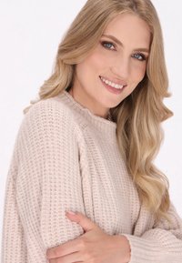 Licht beige gebreide trui met een gestructureerd patroon en een geribde ronde hals, met losse mouwen en een ontspannen pasvorm.