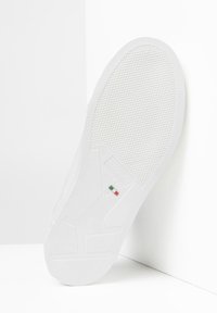 Suela de zapatilla blanca con superficie de goma texturizada, con detalle de la bandera italiana e inscripción de la marca "NeroGiardini" y tamaño "42."