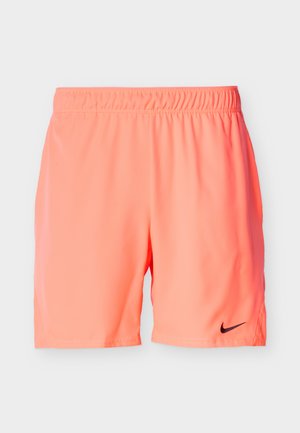 Pantalones cortos deportivos de color coral brillante con cintura elástica y pequeño logo negro de Nike en la parte inferior izquierda, exhibidos sobre un fondo liso.