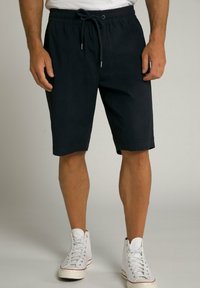 Dunkelmarineblaue Shorts aus weichem Stoff, mit einem Kordelzugbund und einem lässigen Schnitt, kombiniert mit weißen High-Top Sneakers.