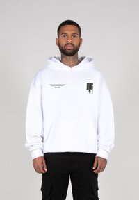 White hooded sweatshirt with a front pocket, featuring black graphic prints on the chest and left side. Soft, cotton blend material.