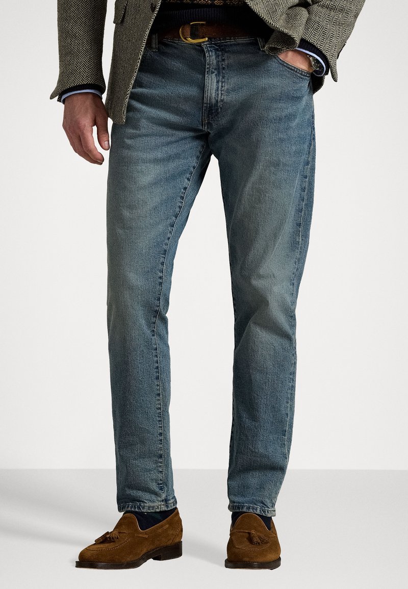 Light blue denim jeans with a straight-leg design, featuring a mid-rise waist, subtle faded areas, and classic five-pocket styling.