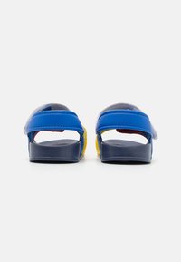 Sandalias bicolor con parte superior azul, forro gris y suela azul marino. Cuenta con correas elegantes con un acento colorido cerca del talón y una plantilla texturizada.