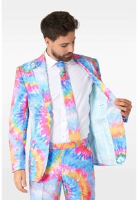 Colorful tie-dye suit featuring blue, pink, and yellow patterns with a matching tie. The interior lining is light blue. Smooth fabric, fitted design.