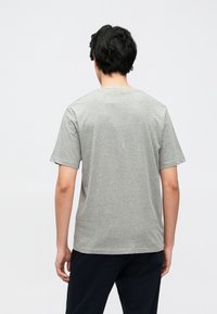 Grå t-skjorte laget av bomull, med korte ermer, rund hals og en avslappet passform. Enkelt design uten synlige mønstre eller detaljer.