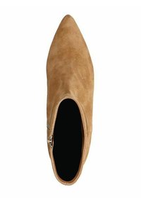 Bottine en suede beige clair avec un bout pointu et un détail de fermeture éclair sur le côté. L'intérieur est noir, montrant une texture lisse.