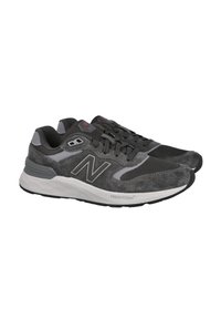 Zapatillas de ante y malla gris con acentos negros y una suela blanca. Presenta un prominente logo "N" y la marca "Fresh Foam" en el lateral.