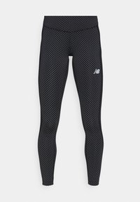 Svarta leggings med vita prickar, en figurnära design, elastisk midja och New Balance-logotyp i vitt på nedre benet.