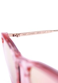Růžové sluneční brýle s průhledným rámem, reflexními skly a kovovými rameny, na jejichž vnitřní straně jsou vyryté značky UV400 a kategorie.