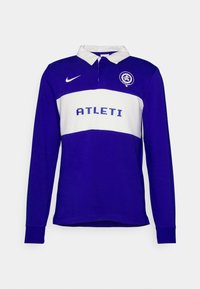 Långärmad polo i djup lila med ett vitt horisontellt rand. Har en knäppbar krage, "ATLETI"-logotyp och Nike-swoosh emblem.