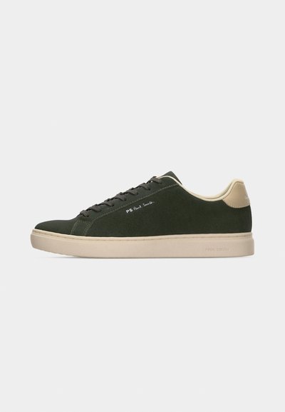 Σκούρο πράσινο sneaker χαμηλού τύπου με μπεζ σόλα και ταμπελάκι στη φτέρνα, μαύρα κορδόνια και λογότυπο "PS Paul Smith" στο πλάι.