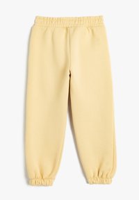 Gelbe Sweatpants aus weichem Stoff, mit einem elastischen Bund und elastischen Bündchen an den Knöcheln. Glatte Textur, lässiges Design.