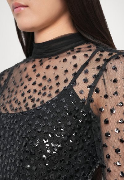 Black mesh top featuring a high neckline, adorned with intricate black and silver sequins in a scattered pattern, accentuating texture and depth.