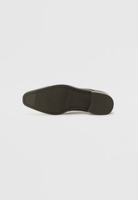 Suola nera di scarpa con una finitura liscia, caratterizzata da una punta arrotondata e una sottile texture geometrica sulla superficie. Tacco piatto, materiale durevole.