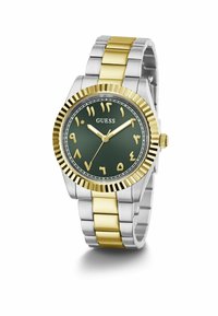 Montre ronde bicolore avec un boîtier en or et un cadran vert. Caractéristiques des marqueurs d'heure en or audacieux, un bracelet en acier inoxydable, et une couronne sur le côté.