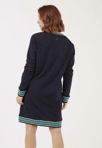 Robe longue à manches longues navy avec des accents rayés verts, blancs et turquoise aux poignets et à l'ourlet. Tissu doux avec une coupe décontractée et un col rond.