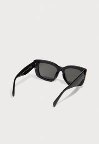 Black sunglasses with a rectangular frame, dark lenses, glossy finish, and slender arms. Includes subtle branding detail on the side.