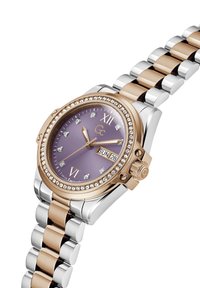 Zegarek ze stali nierdzewnej w kolorze różowego złota i srebrnym z fioletową tarczą, kryształowymi znacznikami godzin, wyświetlaczem daty oraz dwu-tonową bransoletą.