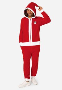 Rode fleece onesie met witte accenten die een kerstmanspak imiteren, voorzien van een capuchon met een kerstmuts aan de bovenkant en een binnenvoering met patroon.