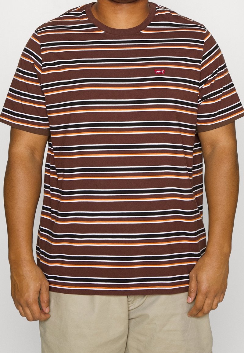 Camiseta de rayas marrón y naranja hecha de algodón con cuello redondo. Presenta un pequeño logo rojo de Levi's en el lado izquierdo del pecho. Mangas cortas.
