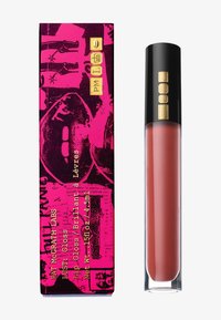 Tubetto di lucidalabbra con tappo nero ed emblema dorato accanto a una scatola con pattern vivace rosa e nera, che presenta un volto stilizzato e testi dorati.