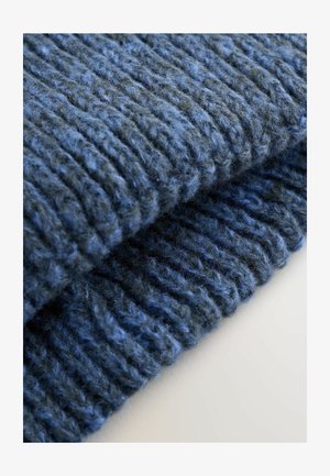 Tmavomodrá rebrová pletenina s rôznymi odtieňmi modrej, s jemným, textúrovaným povrchom a mierne chlpatejším vzhľadom.