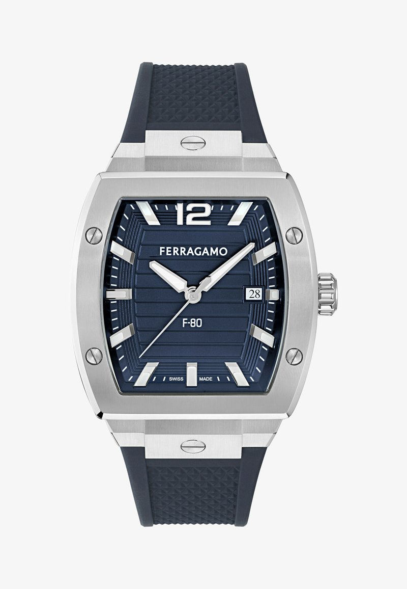 Silverfärgad rektangulär klocka med en marinblå urtavla, texturerat gummirem och silverdetaljer. Funktioner inkluderar datumvisning och upphöjda timmarkörer.