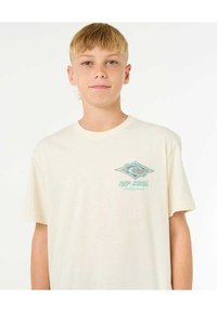 Kremowy t-shirt z krótkim rękawem wykonany z bawełny. Posiada niebieski wzór graficzny na lewej części klatki piersiowej z napisem "RIP CURL."